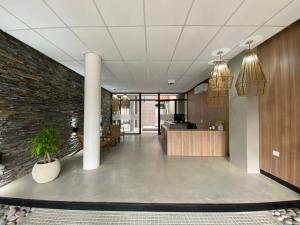 an office lobby with a brick wall and pendant lights at Glo apart hotel in Cañuelas