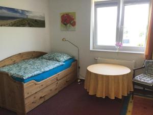 ein kleines Schlafzimmer mit einem Bett und einem Tisch in der Unterkunft Ferienapartment Hartung in Heikendorf