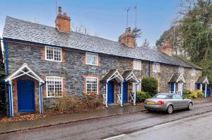 a stone house with a car parked in front of it at Brand Hill Cottage with Hot Tub in Loughborough