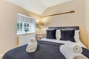 una camera da letto con un letto e asciugamani di Brand Hill Cottage with Hot Tub a Loughborough