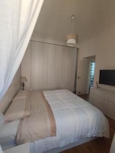 a bedroom with a large white bed and a television at Casa Mancini in Rome