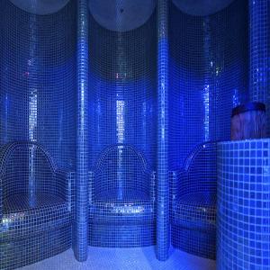 a room with blue tiled walls and a man standing in front at TeoDorka Med & SPA in Ciechocinek +58 photos