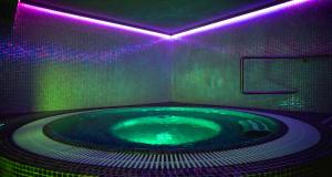 a bathroom with a hot tub with purple lights at TeoDorka Med & SPA in Ciechocinek