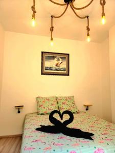 a bedroom with a bed with two black swans on it at Charmante maison de village Collioure in Collioure