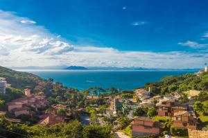 uma cidade numa colina com o oceano ao fundo em La Pedrera Small Hotel & Spa em Búzios