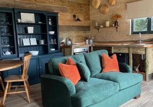 a green couch with orange pillows in a kitchen at Old Oak Farm in Oakham