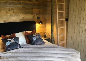 een slaapkamer met een bed met kussens en een boekenplank bij Old Oak Farm in Oakham