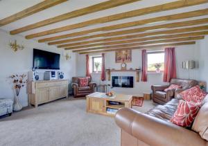 a living room with a couch and a tv at The Old Cow Byre in Lealholm