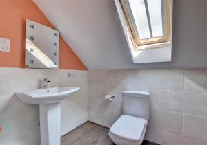 a bathroom with a sink and a toilet and a skylight at The Old Cow Byre in Lealholm +11 photos