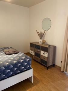 um quarto com uma cama e uma cómoda com um espelho em Confortable et agréable T1 n 2 em Ussel