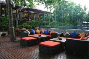a patio with tables and chairs and a pool at Palita Lodge - SHA Plus in Haad Rin
