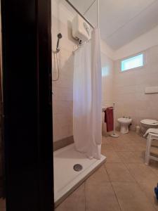 W łazience znajduje się prysznic z białą zasłoną prysznicową. w obiekcie Casa Solanas new w mieście Sìnnai