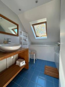 La salle de bains est pourvue d'un lavabo et d'un miroir. dans l'établissement Maison de charme dans la nature, à Clohars-Fouesnant