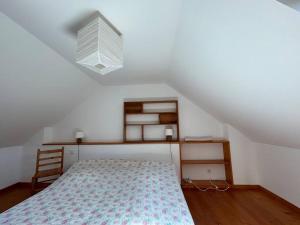 a small bedroom with a bed and a light at Maison de charme dans la nature in Clohars-Fouesnant