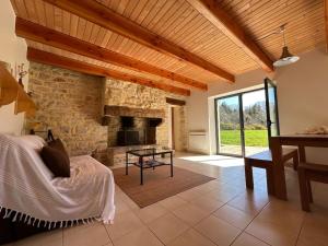 sala de estar con chimenea de piedra y mesa en Maison de charme dans la nature en Clohars-Fouesnant