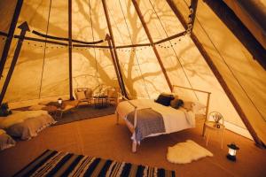 a bedroom in a tent with a bed in it at GreenWood Family Park in Y Felinheli