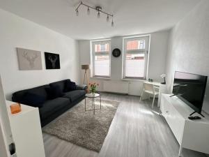 uma sala de estar com um sofá e uma televisão em Möblierte EG- Wohnung zentral in Herne mit Parkplatz,WLAN und Netflix em Herne