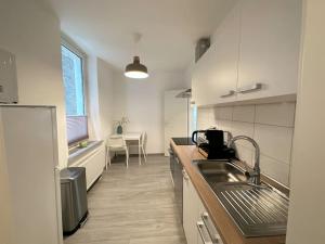 uma cozinha com um lavatório e uma bancada em Möblierte EG- Wohnung zentral in Herne mit Parkplatz,WLAN und Netflix em Herne