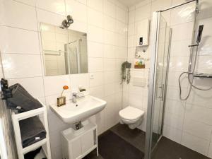 y baño con aseo, lavabo y ducha. en Möblierte EG- Wohnung zentral in Herne mit Parkplatz,WLAN und Netflix, en Herne