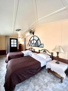 a hotel room with three beds and a lamp at NN Apartment in Pattaya South