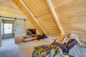 uma sala de estar em cabana de madeira com uma televisão e um sofá em Mountain-View Front Range Colorado Vacation Rental em Red Feather Lakes