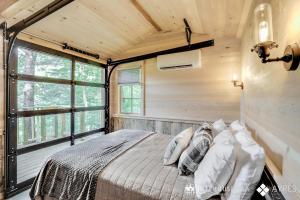 a bedroom with a bed in a room with a window at The Blackjack Oak in Treehouse Grove at Norton Creek in Gatlinburg