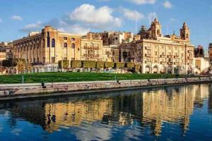 een groot gebouw naast een waterlichaam bij TOP RATED Traditional Maltese house close to Valletta RARE FIND in Cospicua