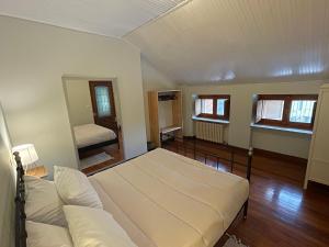 a room with a bed and a couch and windows at La casa di Ottavio in Giaveno