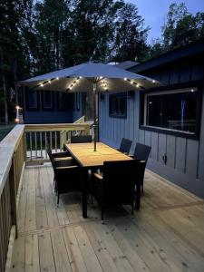 a wooden table with chairs and an umbrella on a deck at Eagle's Nest Cottage - Lake Anna Waterfront in Bumpass +19 photos