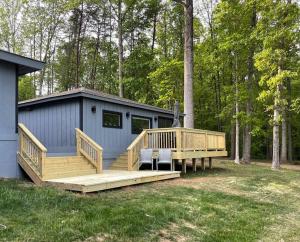 a small cabin with a deck and a house at Eagle's Nest Cottage - Lake Anna Waterfront in Bumpass