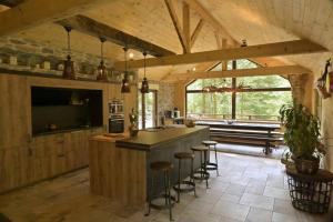 eine Küche mit einer Bar mit Hockern und einem TV in der Unterkunft Chalet : le moulin du sagard in Wisches