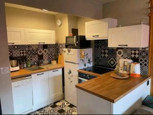 a kitchen with white cabinets and a white refrigerator at Appartement Lamoura in Lamoura