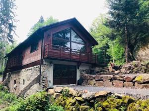 a house with a balcony on the side of it at Chalet : le moulin du sagard in Wisches