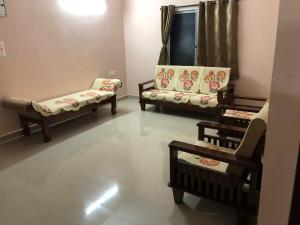 a living room with two chairs and a window at Tirumala Elite Homestay (near Railway station & Bustand) in Tirupati