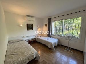 um quarto com 2 camas e uma grande janela em CASA MAS NOU 24 em Platja d'Aro