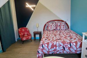 sypialnia z czerwonym łóżkiem i czerwonym krzesłem w obiekcie L'appartement de la Place w mieście Saint-Valéry-en-Caux