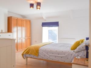 a bedroom with a bed and a window at Snowdrop Cottage in Fishguard