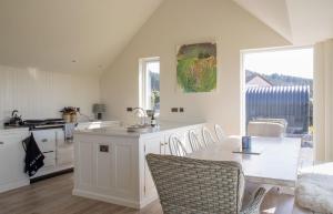 a kitchen and dining room with a table and chairs at No 6 Oskaig in Raasay