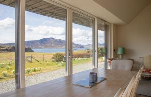 a dining room with a table and a large window at No 6 Oscaig in Raasay