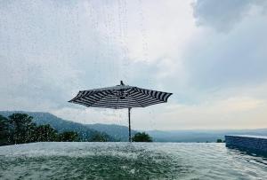 um guarda-chuva sentado na água ao lado de uma massa de água em SANKARA GARDEN 