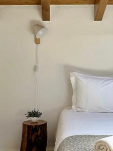 a bedroom with a bed and a lamp on a table at Pure Flor de Esteva in Vila do Bispo