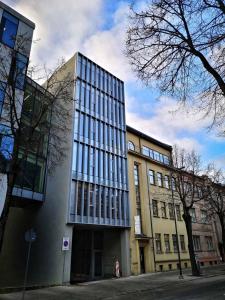 een hoog gebouw met veel ramen aan een straat bij City Center Panorama apartment in Kaunas