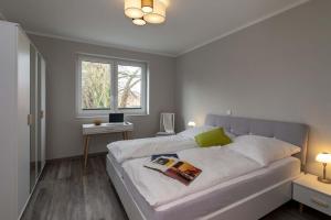 - une chambre avec un grand lit blanc et une fenêtre dans l'établissement Exclusive apartment on Fehmarn, à Petersdorf auf Fehmarn