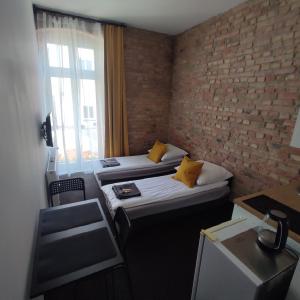 duas camas num quarto com uma parede de tijolos em Rybaki 6A em Poznań
