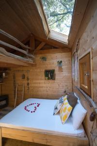 Bett in einem Blockhaus mit Fenster in der Unterkunft Le mas cabanids in Maureillas