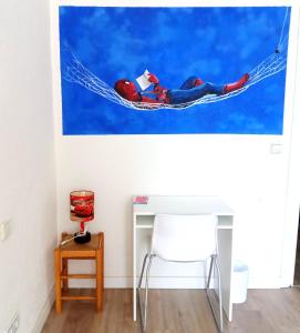 una habitación con escritorio y una pintura de un hombre en una hamaca en Guest House Éxito en Madrid, en Madrid