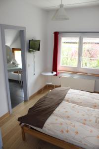 A CÔTE في Môtiers: غرفة نوم بسرير ومكتب ونافذة