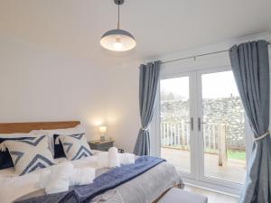 a bedroom with a bed and a sliding glass door at Pebble Cottage in Portree