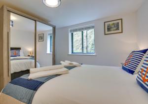 a bedroom with a large white bed and a mirror at Zephyr in Fowey