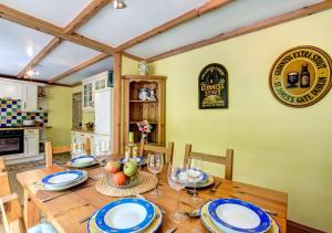 a dining room with a wooden table with blue and white plates at Woodbine Cottage in Saint Hilary